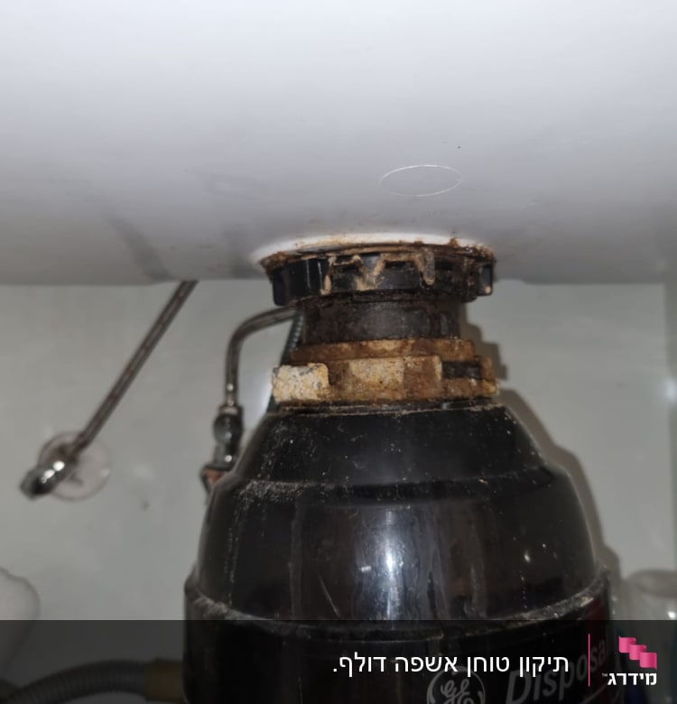 מכשיר טוחן אשפה מתחת לכיור עם צינורות